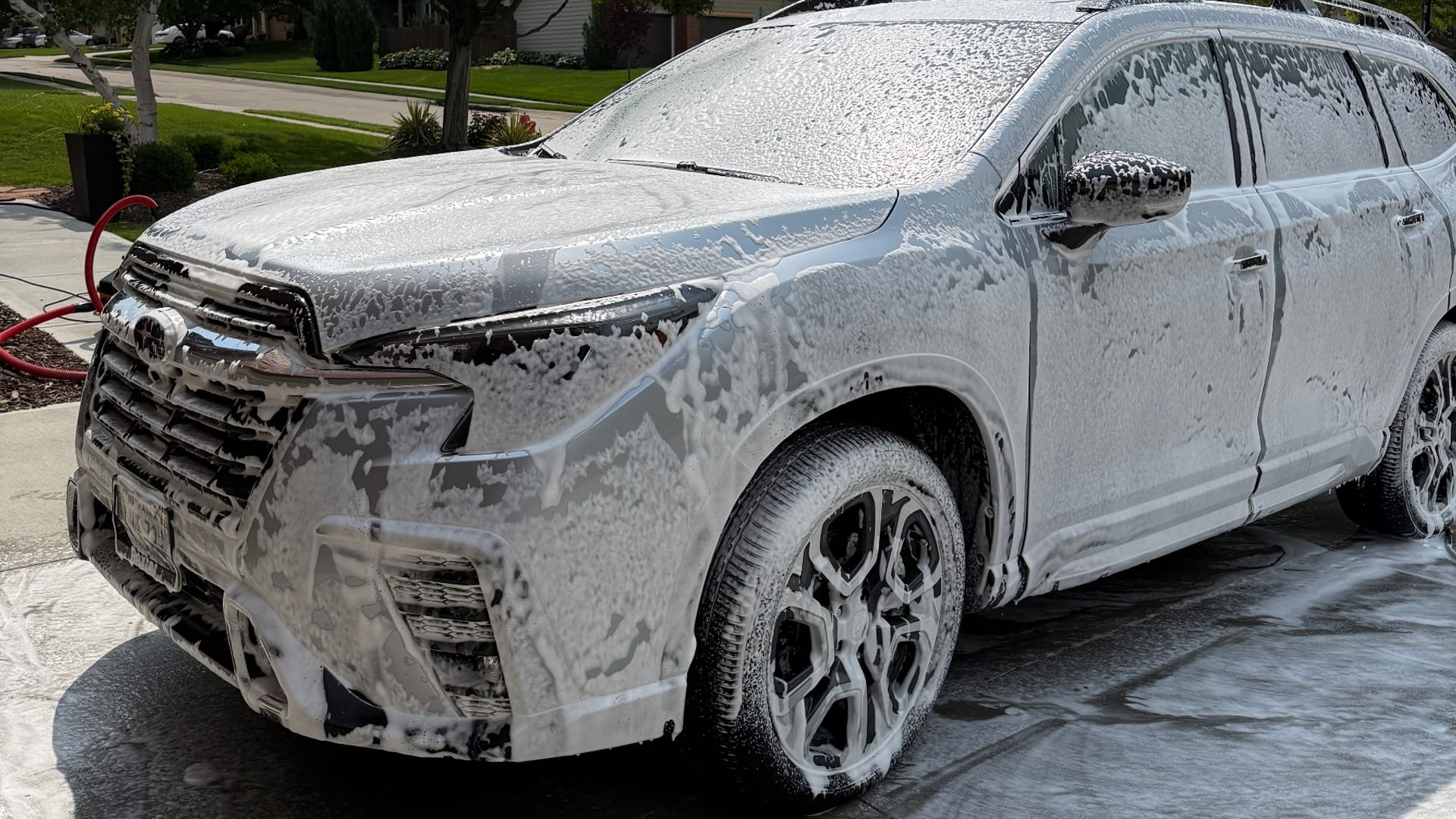 A foam-covered SUV mid-wash by A & A Mobile Detailing in an Omaha driveway